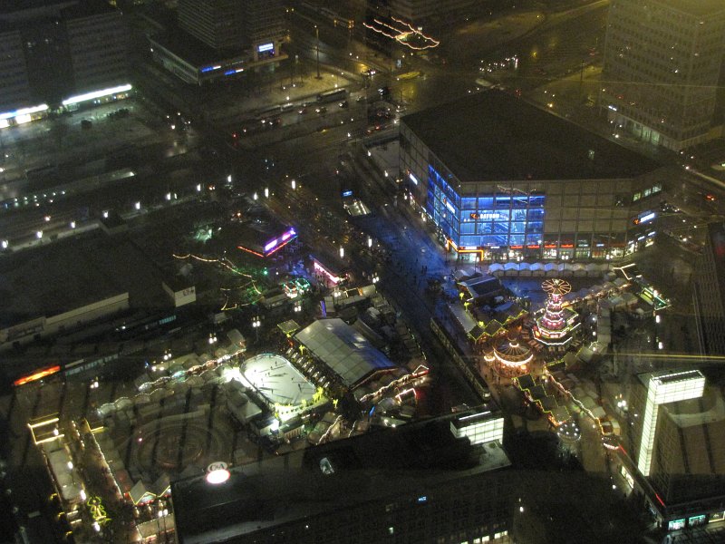 kerstmarkt alexanderplatz.jpg - Het uitzicht valt me een beetje tegen. De verdieping van de televisietoren waar we staan heeft vrij veel verlichting aan die in de ramen weerspiegeld. Op de foto de kerstmarkt van de Alexanderplatz.